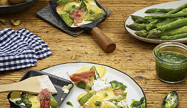 Raclette-Pfännchen mit grünem Spargel und Schinken