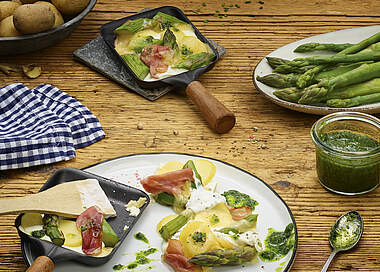 Raclette-Pfännchen mit grünem Spargel und Schinken