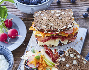 Belegtes Käsebrot mit knusprigem Bacon und Blaubeer-Frischkäse