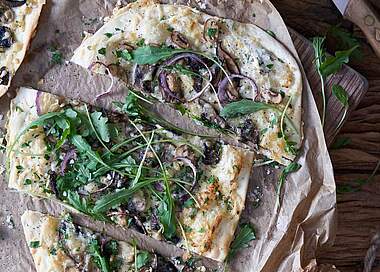 Vegetarischer Flammkuchen mit Rucola und Pilzen