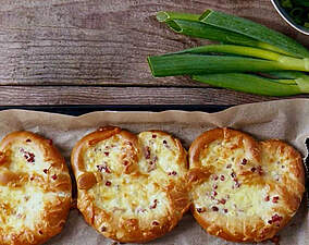 Überbackener Brezel-Snack mit Schinkenwürfeln, Käse und Zwiebelquark