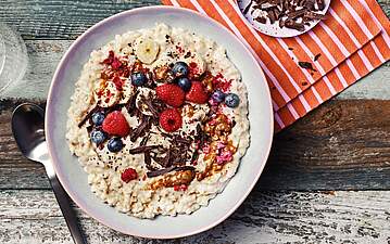 Cremige Vanille-Porridge Bowl mit Mandelmus & Himbeeren