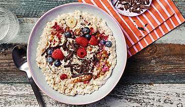 Cremige Vanille-Porridge Bowl mit Mandelmus & Himbeeren