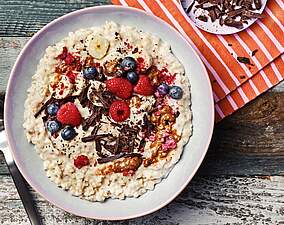Cremige Vanille-Porridge Bowl mit Mandelmus & Himbeeren