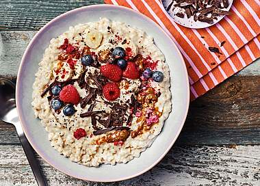 Cremige Vanille-Porridge Bowl mit Mandelmus & Himbeeren