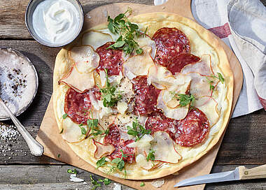 Leckerer Aioli-Flammkuchen mit Fenchelsalami und Birnen