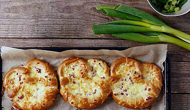 Überbackener Brezel-Snack mit Schinkenwürfeln, Käse und Zwiebelquark