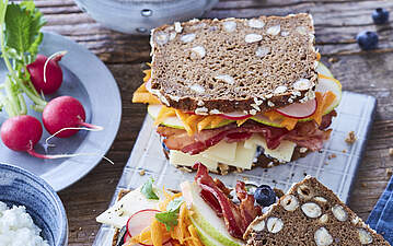 Belegtes Käsebrot mit knusprigem Bacon und Blaubeer-Frischkäse