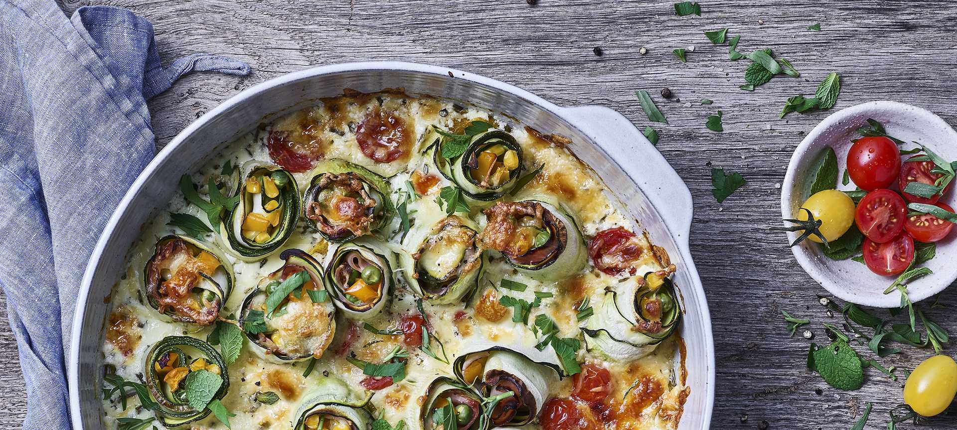Rezeptbild für Bunter Auflauf: Überbackene Zucchini-Röllchen mit Paprika & Schinken