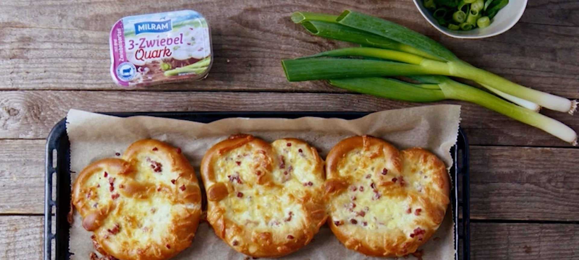 Überbackener Brezel-Snack mit Schinkenwürfeln, Käse und Zwiebelquark ...