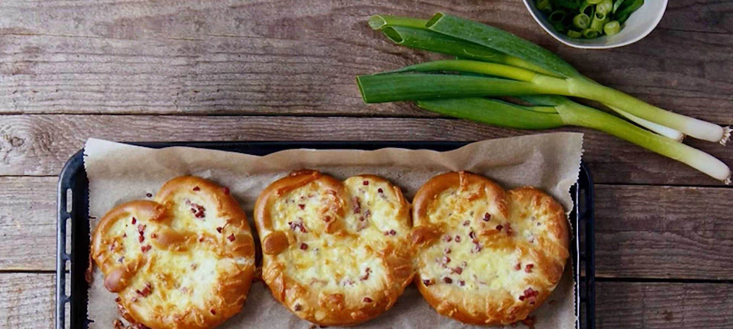 Überbackener Brezel-Snack mit Schinkenwürfeln, Käse und Zwiebelquark ...